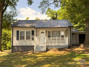 Charming home featuring a quaint porch, complemented by fresh, neutral siding and a durable metal roof at 608 E 11Th St, Newton, NC 28658