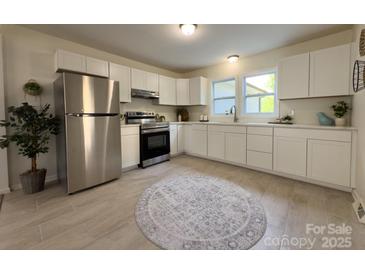 Bright kitchen features modern appliances, white cabinets, light countertops and tile flooring at 608 E 11Th St, Newton, NC 28658