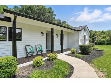 Charming home featuring a cozy front porch with seating and beautifully landscaped front yard at 7109 Forney Hill Rd, Denver, NC 28037