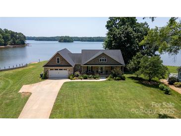 Charming waterfront home with lush lawn, mature trees, and a tranquil lake view at 735 Pebble Pt, Salisbury, NC 28146