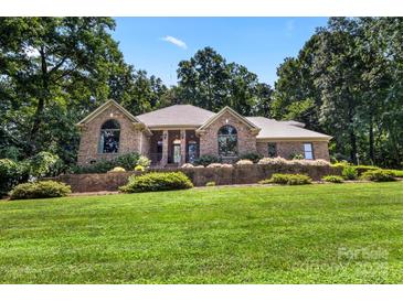 Beautiful brick home with manicured lawn and mature trees, offering curb appeal at 107 Creekwood Dr, Dallas, NC 28034