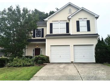 Charming two-story home with a two-car garage and well-maintained front yard with mature landscaping at 10825 Traders Ct, Davidson, NC 28036