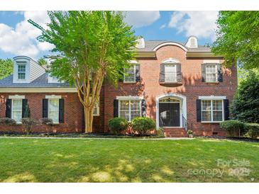 Classic brick home with a well-manicured lawn and mature tree in a desirable neighborhood at 15620 Glen Miro Dr, Huntersville, NC 28078