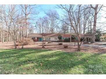 Charming ranch style home with brick accents and a long, private driveway surrounded by mature trees at 251 Gleneagles E Rd, Statesville, NC 28625
