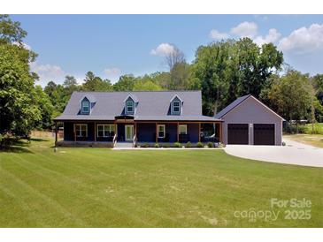 Charming home with a sprawling lawn and a welcoming covered front porch and detached 2-car garage at 265 St Matthews Church Rd, Salisbury, NC 28146