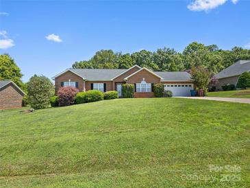 Charming brick home with a well-manicured lawn and mature landscaping, perfect for outdoor enjoyment at 3906 Brickfield St, Hickory, NC 28602