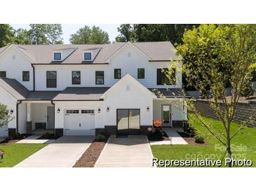 Charming, new construction townhome featuring a white exterior, garage and well-manicured lawn at 622 Station St # 48, Clover, SC 29710