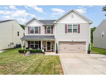 Charming two-story home featuring a well-manicured lawn and inviting front porch at 1216 Catawba Run, Lowell, NC 28098
