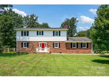 Charming two-story home with a red brick facade and a bright red front door at 4121 Dover St, Claremont, NC 28610