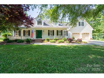 Charming two-story home featuring a landscaped front yard, white porch, and two-car garage at 135 Primrose Dr, Salisbury, NC 28147