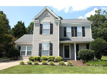 Charming two-story home with gray siding, black shutters and well-maintained landscaping at 148 W Walnut Ave, Mount Holly, NC 28120