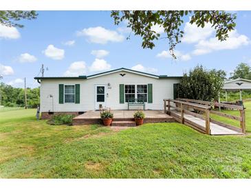 Charming single story home featuring a landscaped yard, front porch, and wheelchair ramp access at 223 Green Meadows Dr, Kings Mountain, NC 28086