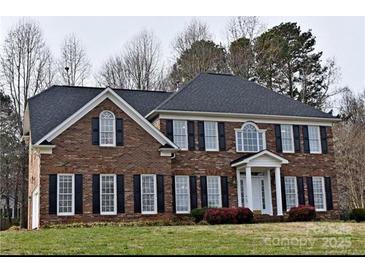 Charming two-story brick home with black shutters and a well-manicured front lawn at 3015 Rochester Ct, Monroe, NC 28110
