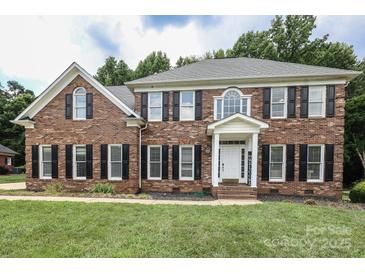 Classic brick two-story home featuring black shutters and a well-manicured lawn at 3015 Rochester Ct, Monroe, NC 28110