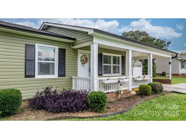 Charming front porch with white railing, columns, and a welcoming wreath on the door, creating a cozy entrance at 3545 Yorkland Dr, Hickory, NC 28601