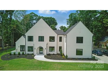 Modern two-story home featuring a white exterior, black framed windows, manicured landscaping, and a charming front entrance at 4208 Antioch Church Rd # 1, Weddington, NC 28104
