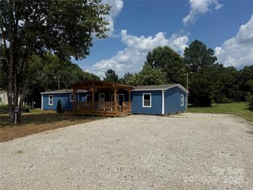Charming blue home featuring a welcoming, covered front porch and ample gravel parking at 4351 Saluda Rd, Rock Hill, SC 29730