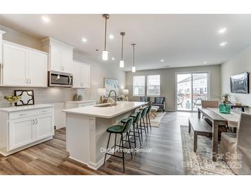 Modern kitchen featuring white cabinetry, stainless steel appliances, and an island with seating at 7126 Hodges Meadow Ln, Charlotte, NC 28213