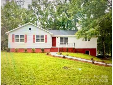 Charming one-story home featuring a cozy front porch and red accents at 7154 Woodcock Trl, Stanley, NC 28164