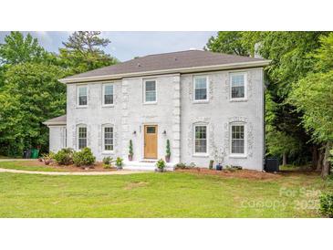 Charming two-story home with a white brick exterior and well-manicured front lawn at 8337 Norcroft Dr, Charlotte, NC 28269