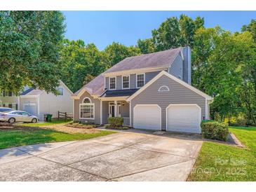Charming gray two-story home featuring an attached two-car garage and mature landscaping at 8909 Elkins Park Dr, Matthews, NC 28105