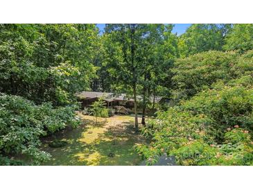 Wood home surrounded by trees featuring green grass and a front porch at 5212 Timber Creek Ct, Kings Mountain, NC 28086