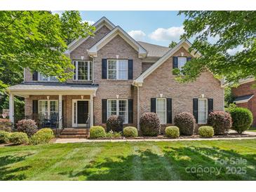 Traditional brick home with a manicured lawn and mature landscaping, enhancing its curb appeal at 9735 Devonshire Dr, Huntersville, NC 28078