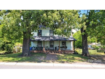 Charming two-story home with a covered front porch and mature trees in the front yard at 164 N Eastway Dr, Troutman, NC 28166
