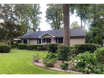 Charming ranch-style home featuring a well-manicured lawn and mature landscaping at 1047 Honeybee Trl, Fort Mill, SC 29715