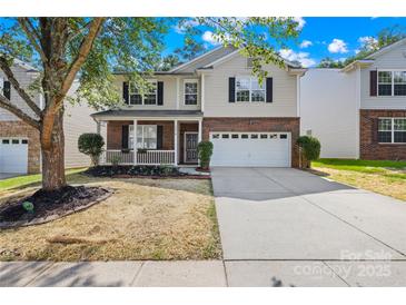 Charming two-story home with brick and siding, a well-manicured lawn, and attached two-car garage at 2316 Savannah Hills Dr, Matthews, NC 28105