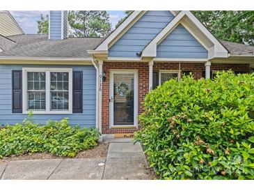 Charming blue home with brick accents and a welcoming front entrance and landscaping at 9136 Four Mile Creek Rd, Charlotte, NC 28277