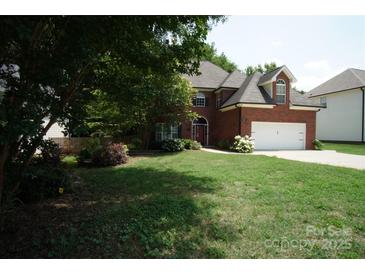Charming brick two-story home with manicured lawn and attached two-car garage at 12520 Vantage Point Ln, Huntersville, NC 28078