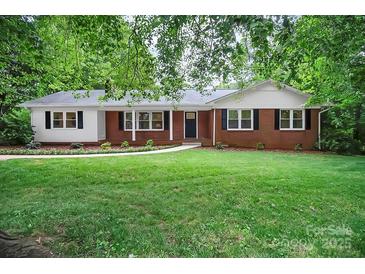 Charming brick home with a well-manicured lawn, inviting entrance and beautiful, mature trees at 1538 Hilltop Dr, Shelby, NC 28150