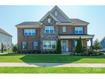 Beautiful two-story brick home with stone accents and a well-manicured front yard at 19012 Beecher Commons Dr, Huntersville, NC 28078