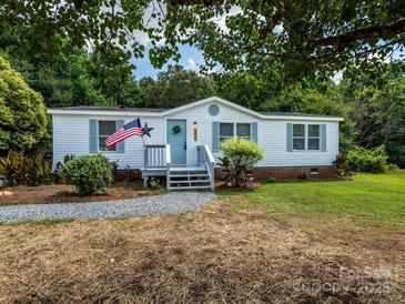 Charming single-story home with a welcoming front porch, beautiful yard, and patriotic American flag at 4833 Verde View Dr, Gastonia, NC 28056