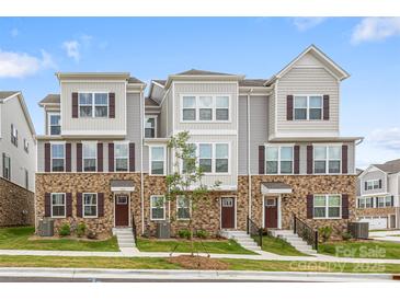 Inviting townhouse featuring brick accents, complementary siding, and well-maintained landscaping at 9921 Oaklawn Nw Blvd, Huntersville, NC 28078