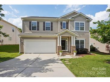 Charming two-story home featuring a two-car garage, landscaped yard, and inviting front porch at 10303 Dominion Village Dr, Charlotte, NC 28269