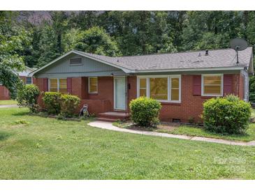 Charming single-story brick home with mature landscaping and a welcoming front porch, perfect for a cozy lifestyle at 1033 Rollingwood Dr, Charlotte, NC 28217