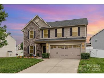 Charming two-story home with a two-car garage, stone accents, and manicured lawn at 12822 Plumleaf Dr, Charlotte, NC 28213