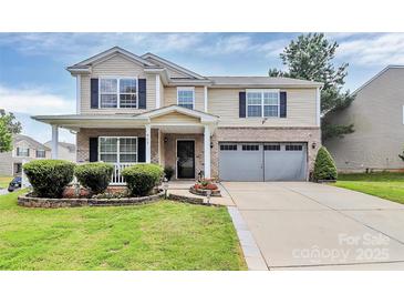 Charming two-story home featuring a well-manicured lawn, brick accents, and an attached two-car garage at 902 Silverberry St, Gastonia, NC 28054