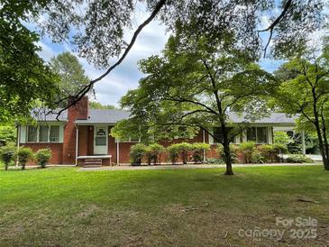 Charming brick home featuring a well-maintained lawn and mature landscaping at 506 Hearne Farm Rd, Mount Gilead, NC 27306