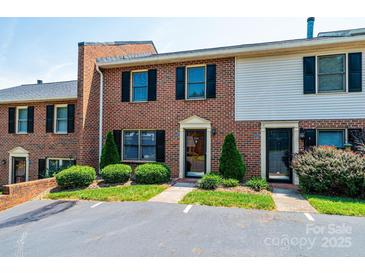 Brick townhouse with black shutters, manicured bushes, and parking at 709 21St Ne Ave, Hickory, NC 28601