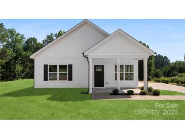 Charming home with a black front door, black shutters, and manicured lawn at 1019 S Main St, Granite Quarry, NC 28146