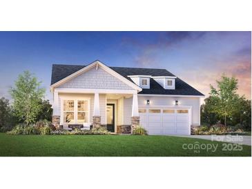 Charming home featuring a two-car garage, manicured lawn, and inviting front porch at 5309 Mint Harbor Way # 0313, Charlotte, NC 28269