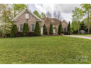 Well-maintained brick home featuring mature landscaping and lush green lawn at 233 Highland Forest Dr, Clover, SC 29710