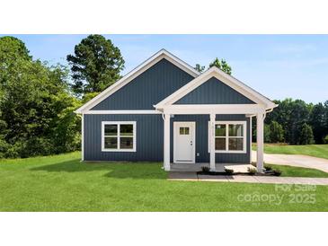 Charming blue home with white trim, well-manicured lawn, and inviting entrance at 1017 S Main St, Granite Quarry, NC 28146