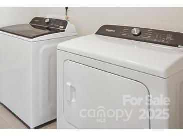 Modern laundry room featuring a white front load washer and dryer set at 132 Satchel Ct, Mooresville, NC 28115
