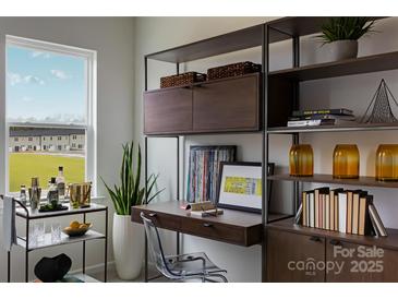 Bright home office featuring custom shelving, modern decor, and a large window at 2230 Endeavor Run, Charlotte, NC 28269