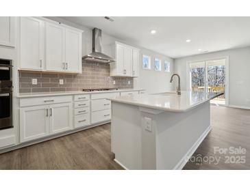 Modern kitchen boasts white cabinets, stainless steel appliances, and a stylish gray backsplash at 180 Glenn Dr, Mooresville, NC 28115