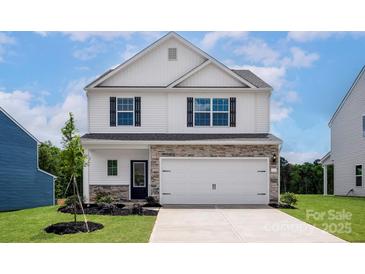 Charming two-story home with stone accents, manicured lawn, and a two-car garage at 7023 Jerimoth Dr, Charlotte, NC 28215